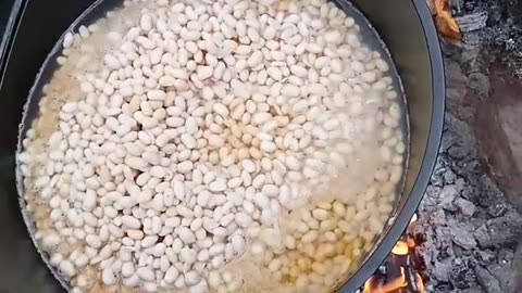 Beans in bacon on a campfire