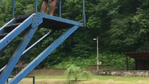 Kid in orange shorts belly flops into lake