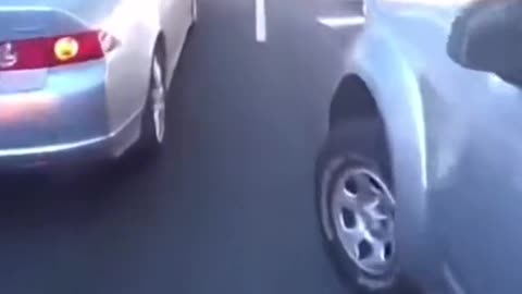 Lady tries to cat biker of thet is going around cars.