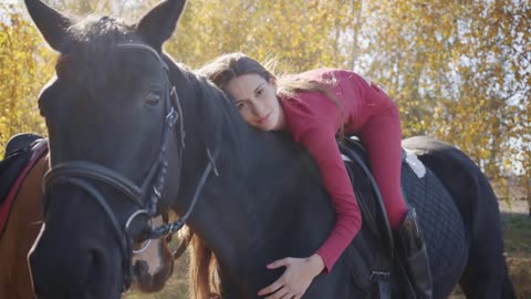 Young Caucasian female equestrian lying on horseback and caressing her pet