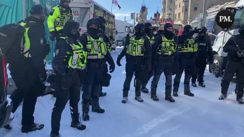 A freedom protestor in Ottawa exits an outhouse that is surrounded by police