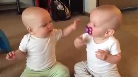 Twin baby girls fight over pacifier