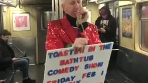 Old man in frog mask and red sequin suit does balloon animal trick