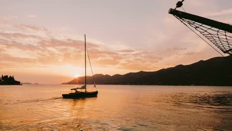 (4K/UHD)Yacht Sailing At Sun Set In Sea With Mountain Loop Free To Use (No Copyright)