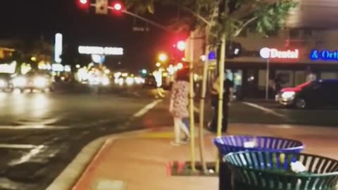 Guy sitting down on street throws up