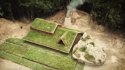 Building underground hut with grass roof & fireplace with clay