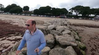 Climbing over boulder on a beach with a selfie stick with the Go pro