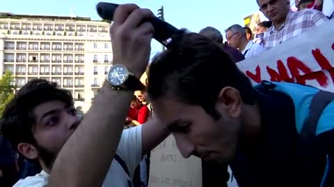 Iranians in Greece cut hair, burn headscarf in protest Sept 25