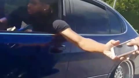 Guy hands off phone from moving car to moving car