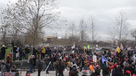 People gather at the steps of the capitol building by the monkey bars / bike rack area