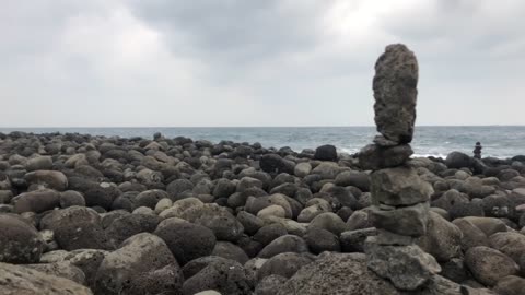 a stone pagoda piled up on the Jeju Island beach