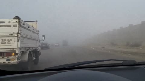 Fog on the oases road in front of the pyramids