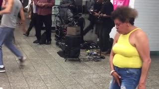 Woman in yellow dancing in subway station