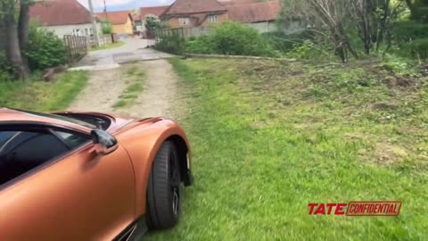 Andrew Tate driving his Bugatti through a village