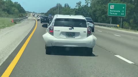 Person Driving Down the Highway While Their Bumper Hangs on for Dear Life