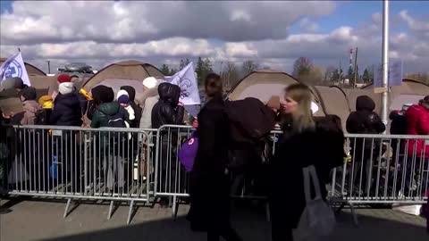 Ukrainians wait for buses at Polish camp