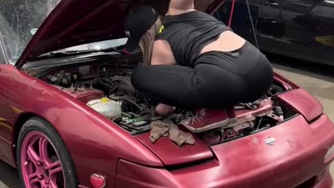 Beauty works very hard when repairing cars.