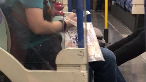 Woman in blue with glasses eating boogers