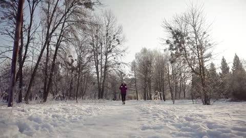 woman walking through snow in winter