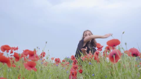 Girl dancing happily in a field of flowers