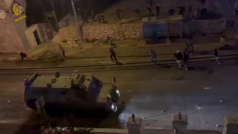 Palestinians throwing stones and Molotov cocktails at Israeli forces vehicles north of Ramallah.