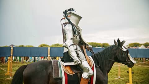 Knight with a massive helmet riding a black horse on the field