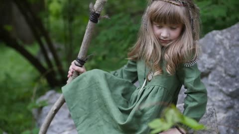 Little girl with an owl in a fairy forest. Friends