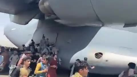 Desperate Afghan civilians cling to the landing gear of a US plane