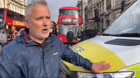 An Insulate Britain protestor glues himself to a police van