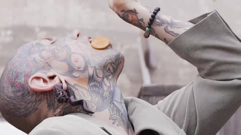 Young Tattooed Man Eating Carrot Slices