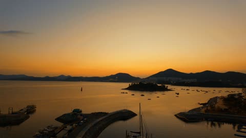 A sunset view of a mountain range behind a beach.