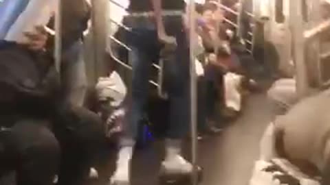 Contortionist twists his arms in a circle, woman on subway watches in disgust