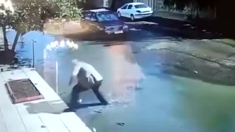 Footage shows a driver rescuing a child from drowning in a giant pothole