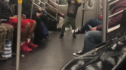 Little boy dances on subway train, hip hop song