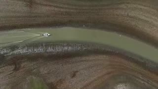 Fishermen drag boats through mud as lake dries up in Brazil