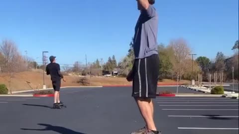 Guy Standing on Balance Board Plays Catch With Skateboarder