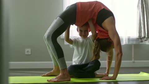 A Boy Supporting The Back Of A bending Woman