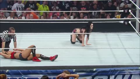 Nikki Bella squares off with Divas Champion Paige while AJ Lee observes from ringside.