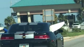 Black car with white board sticking outside the car