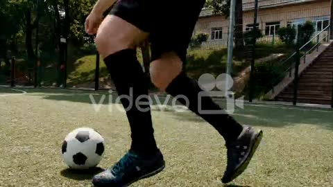 Male Soccer Players Playing On A Street Football Pitch On A Sunny Morning