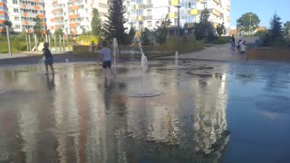 Children play on an underground fountain in Siberia