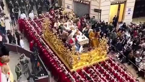 Members of a Catholic brotherhood in Malaga Spain carry a massive 3.5-ton platform reenacting Jesus' Last Supper