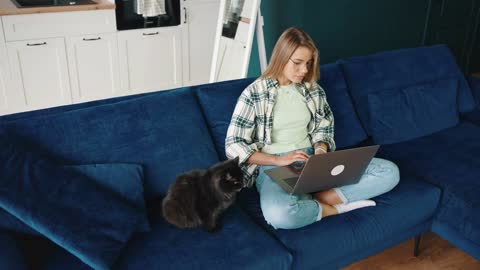 Top view of young concentrated woman typing on laptop, working remotely online