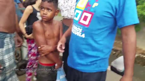 Venezuelans helping one another collect spring water near Guaire River, Caracas (2019)