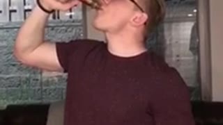 Man red shirt drinking alcohol from bottle