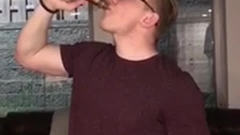 Man red shirt drinking alcohol from bottle