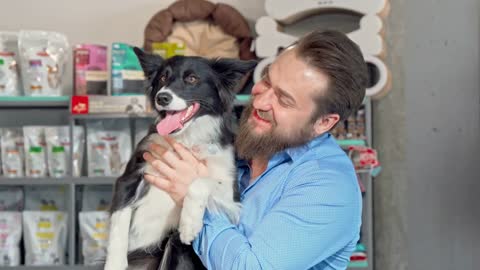 Happy man holding his adorable dog, smiling to the camera