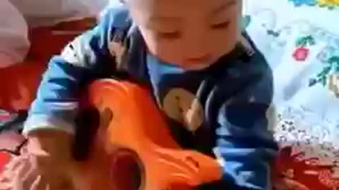 the child is playing the guitar and singing