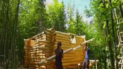 Amazing couple building a long cabin in the forest.