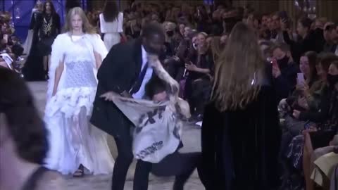 Extinction Rebellion protestor tackled by security at fashion show